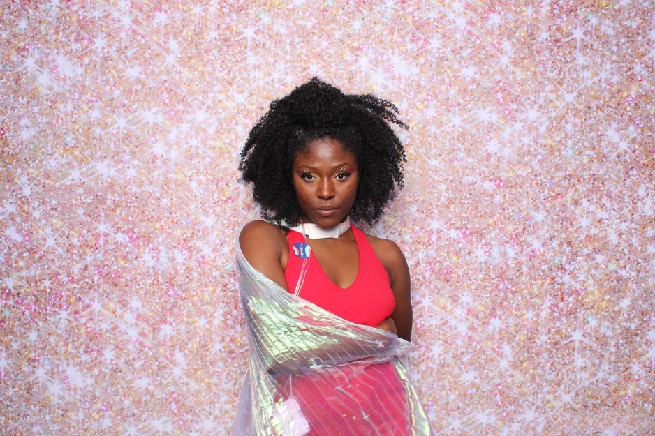 Guest posing against a sparkling photo booth backdrop