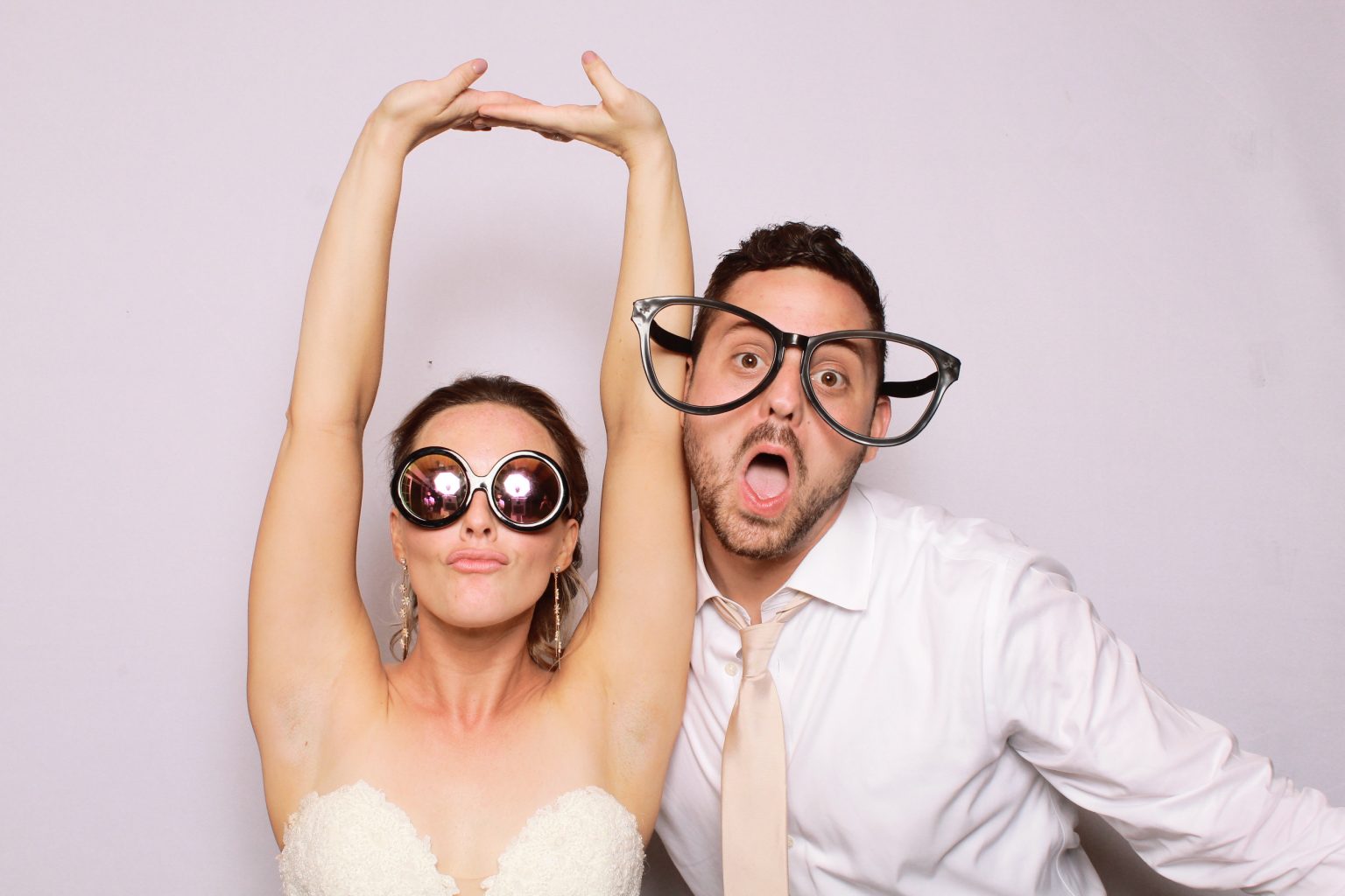 Wedding guests posing in oversized glasses